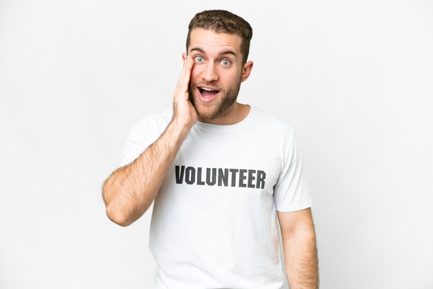 Giovane uomo volontario su sfondo bianco isolato con espressione facciale sorpresa e scioccata