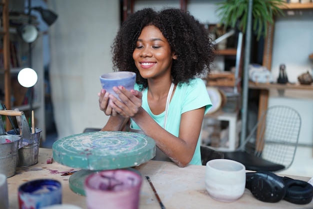 Giovane vasaio afro ragazza mano che fa vaso di argilla in laboratorio di ceramica, imprenditore.