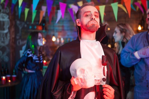 Giovane vestito da vampiro alla festa di Halloween. Ha in mano uno scheletro