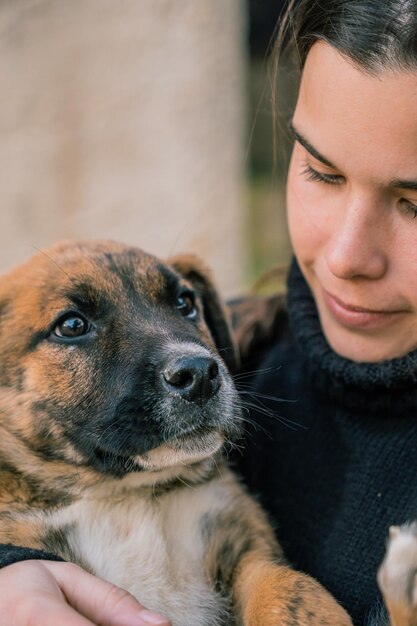Giovane veterinaria che tiene in braccio un cucciolo di cane neonato per un controllo
