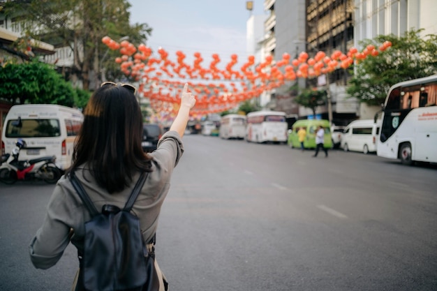 Giovane viaggiatore asiatico dello zaino della donna che gode del mercato dell'alimento della via della città della Cina a Bangkok Tailandia Viaggiatore che controlla le strade laterali