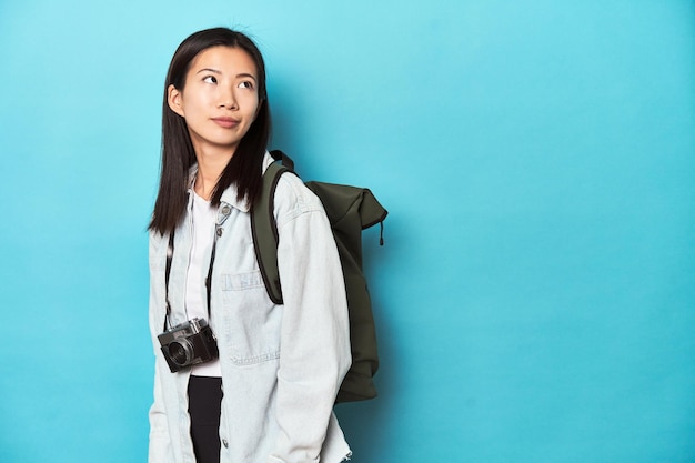 Giovane viaggiatore asiatico pronto a catturare avventure sognando di raggiungere obiettivi e scopi