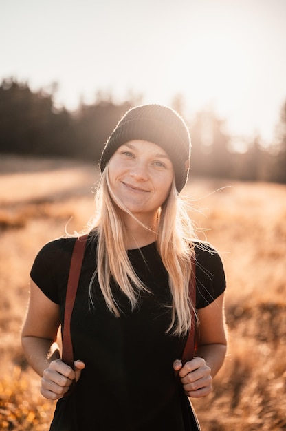 Giovane viaggiatore escursionista ragazza con zaini Escursioni nella natura Atmosfera al tramonto Paesaggio soleggiato Viaggiatore turistico sul modello di vista dello sfondo Escursionista che guarda la luce del sole in viaggio