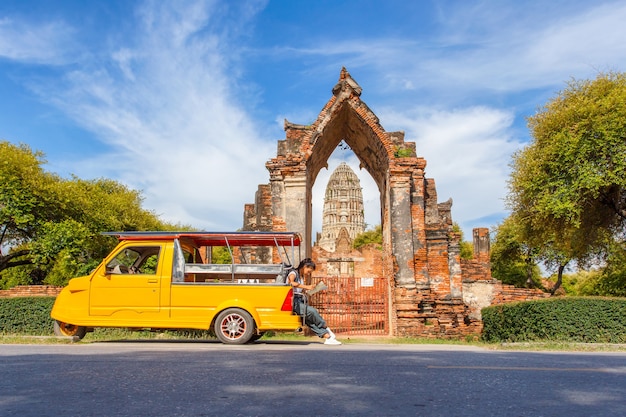 Giovane viaggiatore femminile asiatico con lo zaino che viaggia seduta sul taxi o sul Tuk Tuk