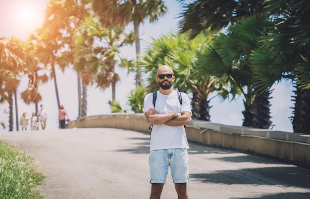 Giovane viaggiatore in vacanza estiva con bellissime palme e paesaggi marini sullo sfondo