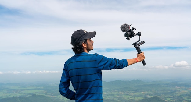 Giovane vlogger asiatico influencer o creatore di contenuti guardando la fotocamera