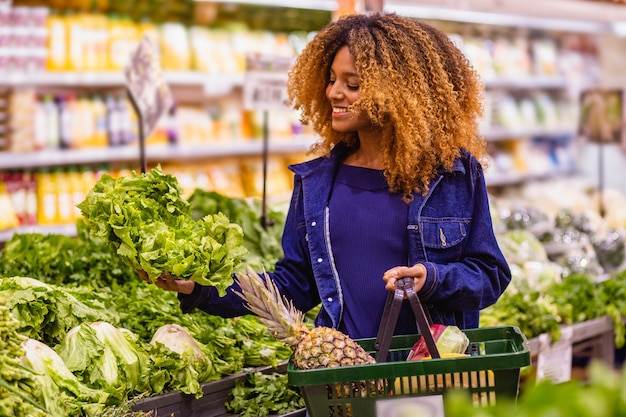 Giovani afro che comprano frutta e verdura al supermercato.