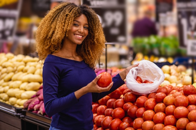 Giovani afro selezionando pomodori al mercato