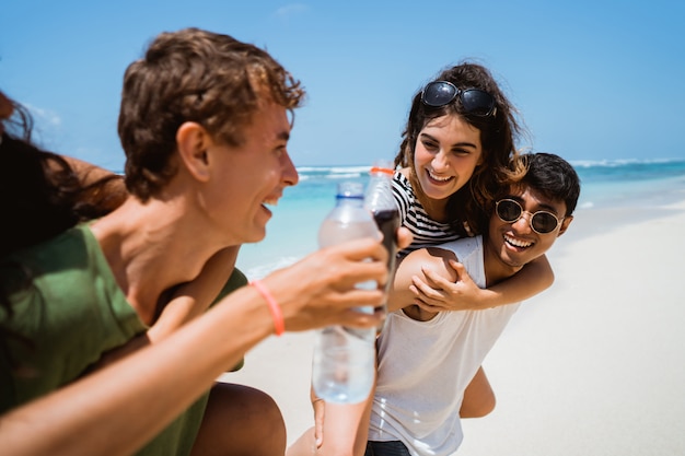 Giovani amici allegri che godono dell'estate sulla spiaggia