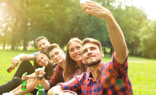 Giovani amici che prendono selfie durante il picnic barbecue