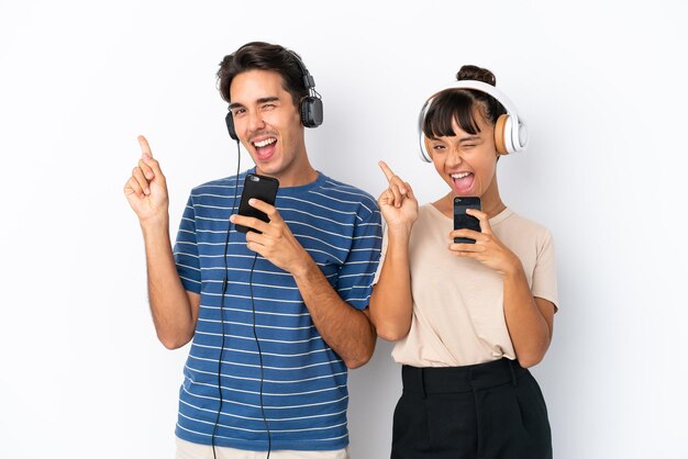 Giovani amici di razza mista isolati su sfondo bianco ascoltando musica con un cellulare e cantando