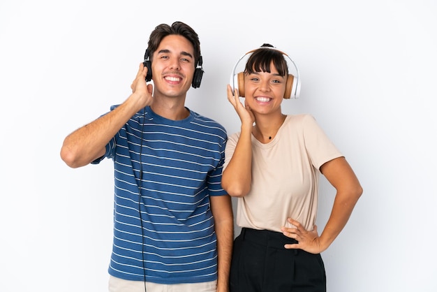 Giovani amici di razza mista isolati su sfondo bianco ascoltando musica