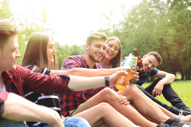 Giovani amici felici che si godono il picnic e mangiano.