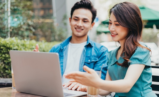 Giovani asiatici che lavorano insieme alla caffetteria