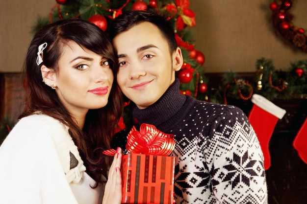 Giovani belle coppie che scambiano i regali a Natale