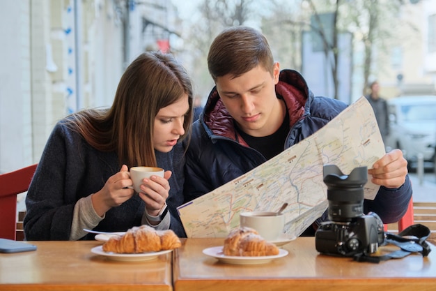 Giovani belle coppie di turisti che riposano in caffè all'aperto