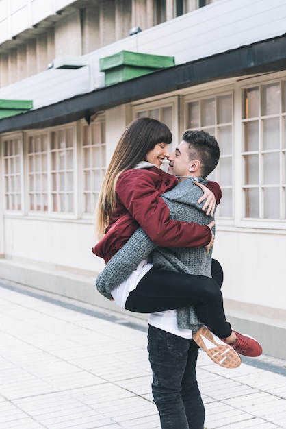 Giovani belle coppie innamorate che si abbracciano nel mezzo della strada in modo romantico