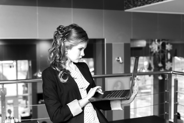 Giovani belle donne in piedi in un caffè e lavorando sul portatile