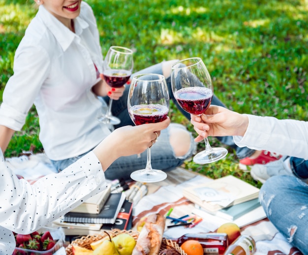 Giovani belle ragazze con bicchiere di vino rosso nel parco