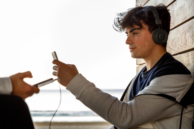 giovani che ascoltano la musica sulla spiaggia