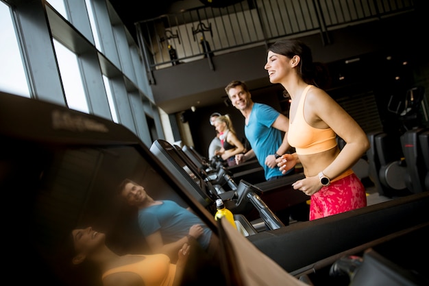 Giovani che corrono sul tapis roulant in palestra moderna