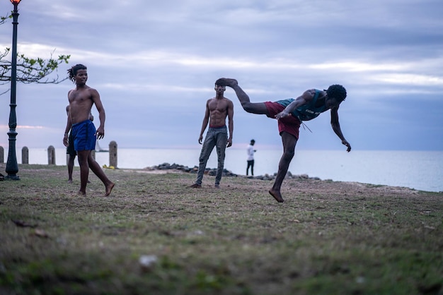 Giovani che esercitano arti marziali sulla spiaggia