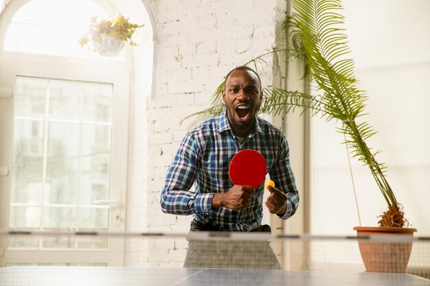 Giovani che giocano a ping pong sul posto di lavoro divertendosi