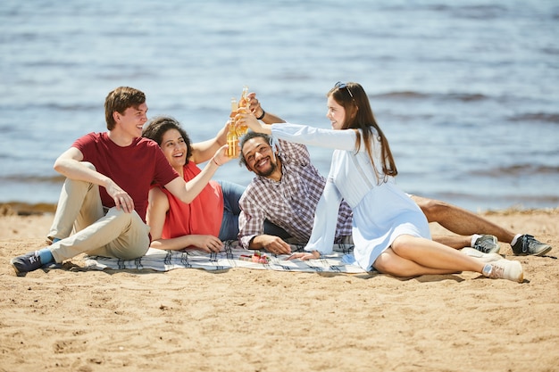 Giovani che godono del picnic sulla spiaggia