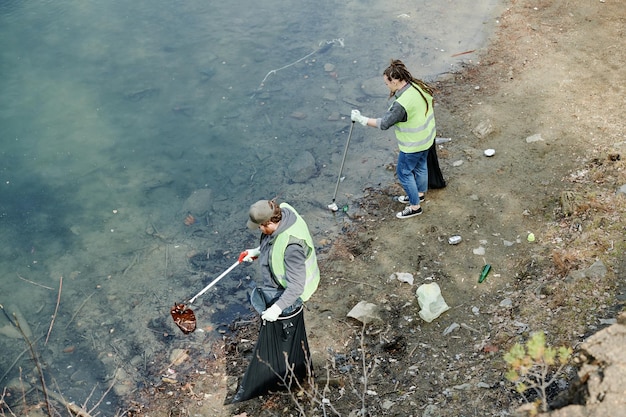 Giovani che puliscono la riva del lago