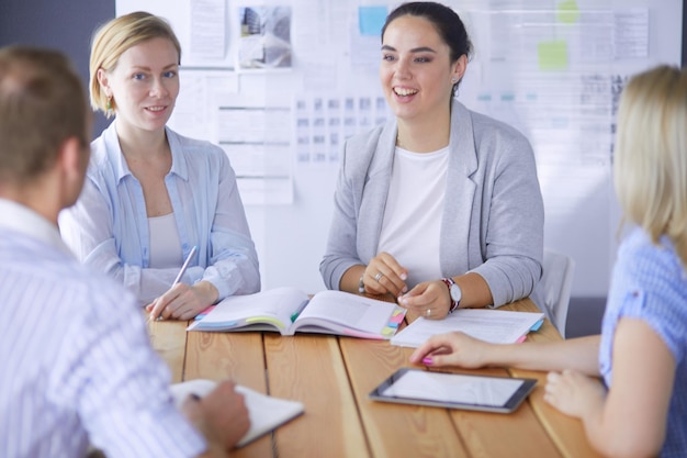 Giovani che studiano con i libri sulla scrivania belle donne e uomini che lavorano insieme