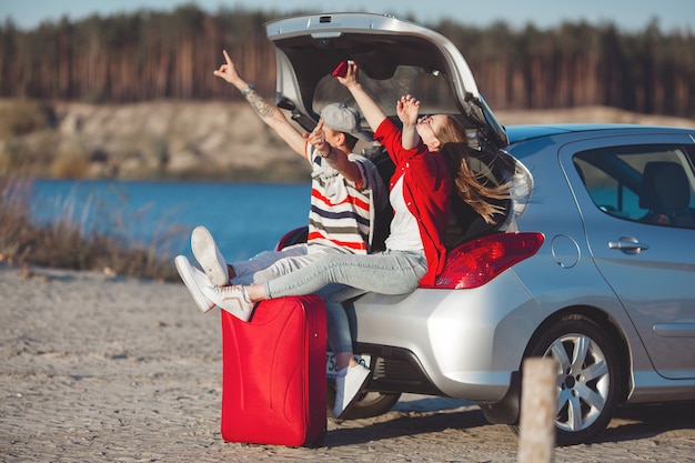 Giovani che viaggiano in macchina. Coppie che hanno un viaggio in automobile.