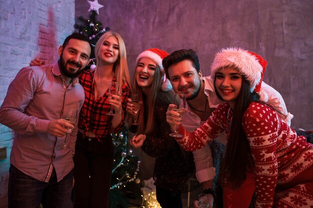 Giovani con bicchieri di champagne alla festa di Natale