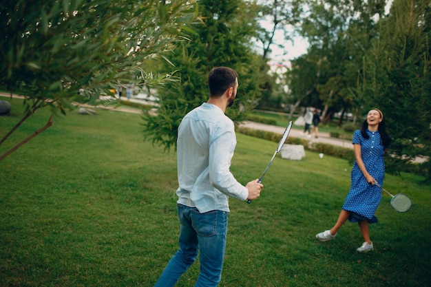 Giovani coppie adulte che giocano a badminton nel parco.