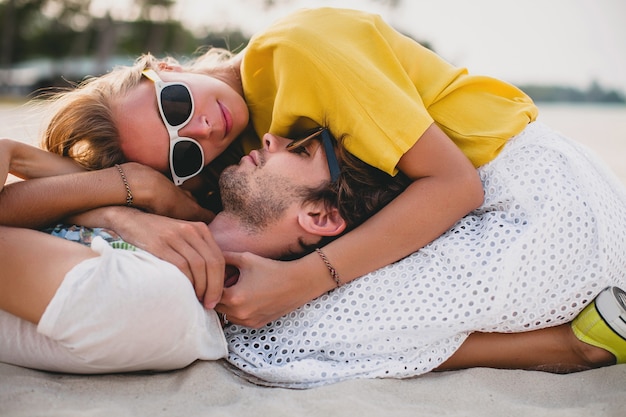 Giovani coppie alla moda hipster nell'amore sulla spiaggia tropicale durante le vacanze