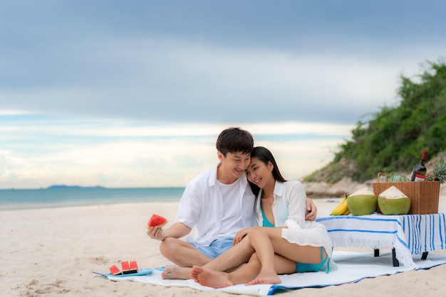 Giovani coppie asiatiche sulla spiaggia