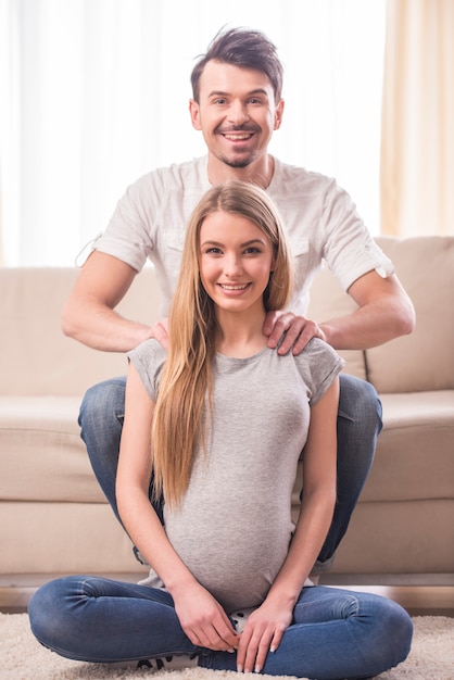 Giovani coppie attraenti, madre incinta e padre felice.