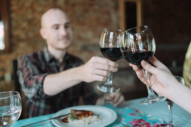 Giovani coppie caucasiche che tostano sulla loro data in un ristorante