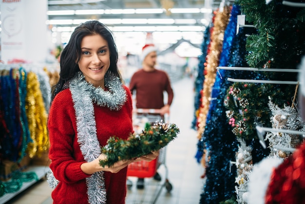 Giovani coppie che acquistano le decorazioni di festa di Natale nel supermercato