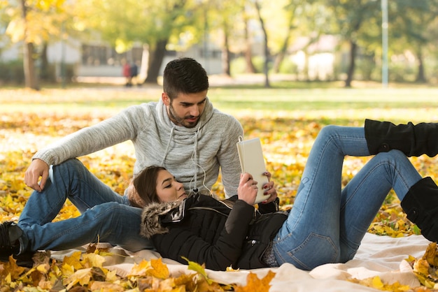 Giovani coppie che ascoltano musica sotto il sole autunnale