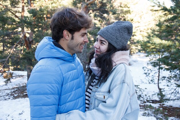 Giovani coppie che baciano in montagna in una giornata nevosa.