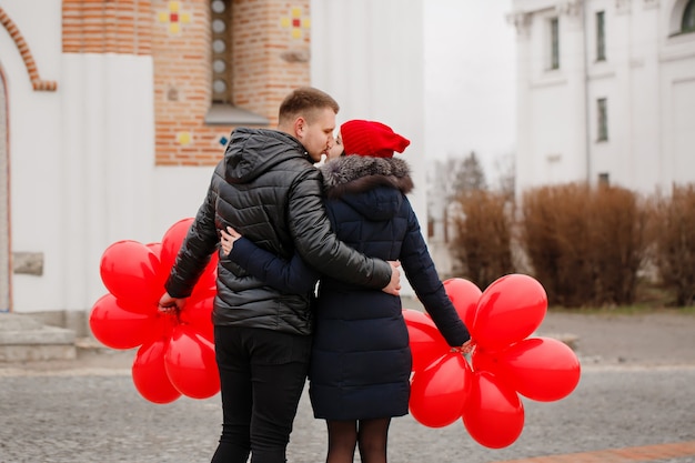 Giovani coppie che camminano con palloncini rossi