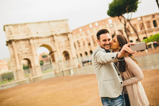 Giovani coppie che catturano selfie davanti al Colosseo a Roma, Italia