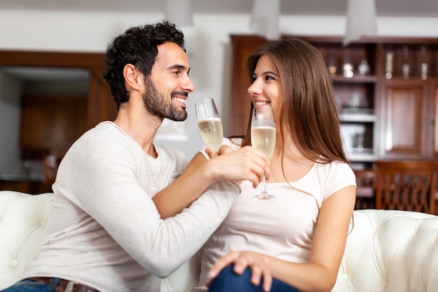 Giovani coppie che celebrano con i bicchieri di champagne