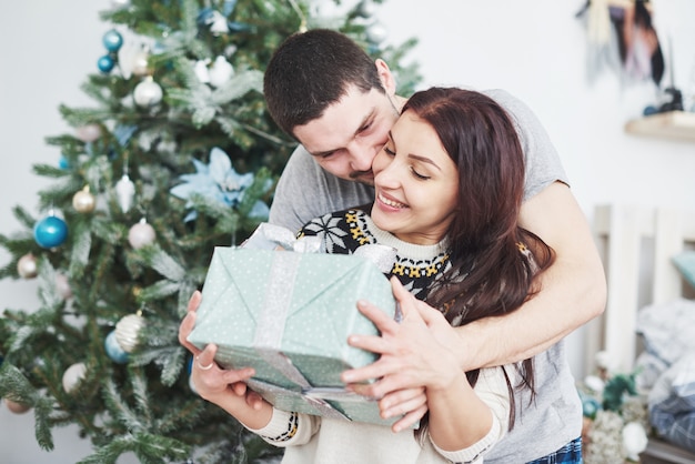 Giovani coppie che celebrano il Natale. Un uomo improvvisamente ha presentato un regalo a sua moglie.