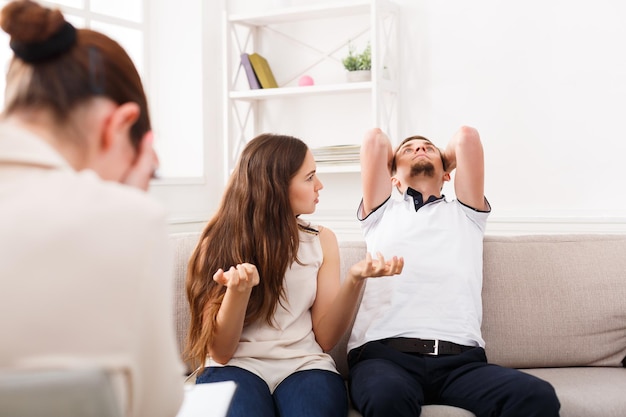 Giovani coppie che discutono durante la sessione di terapia, uomo stanco. Problemi di relazione, concetto di problemi familiari