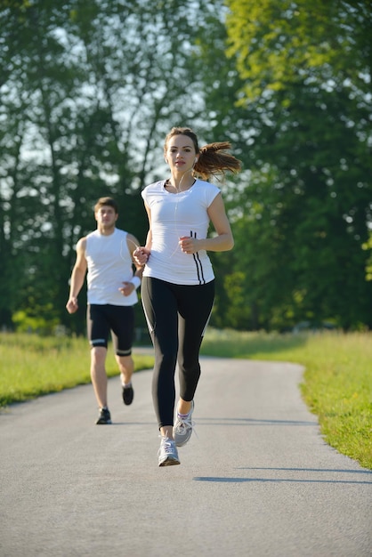 Giovani coppie che fanno jogging nel parco al mattino. Concetto di salute e fitness