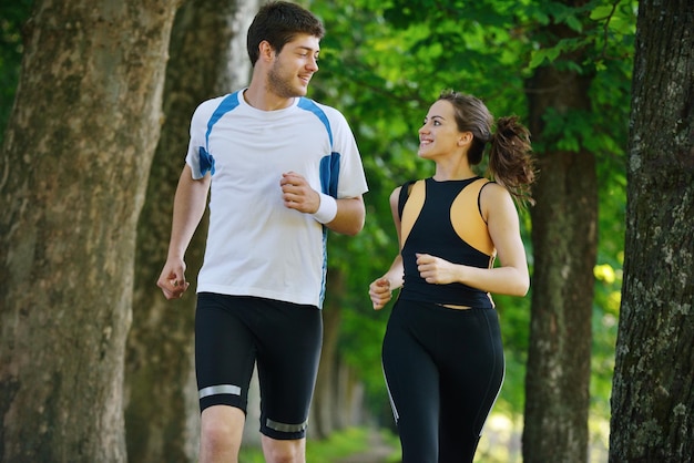 Giovani coppie che fanno jogging nel parco al mattino. Concetto di salute e fitness