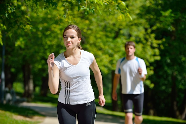 Giovani coppie che fanno jogging nel parco al mattino. Salute e fitness.