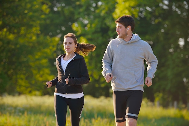 Giovani coppie che fanno jogging nel parco al mattino. Salute e fitness.