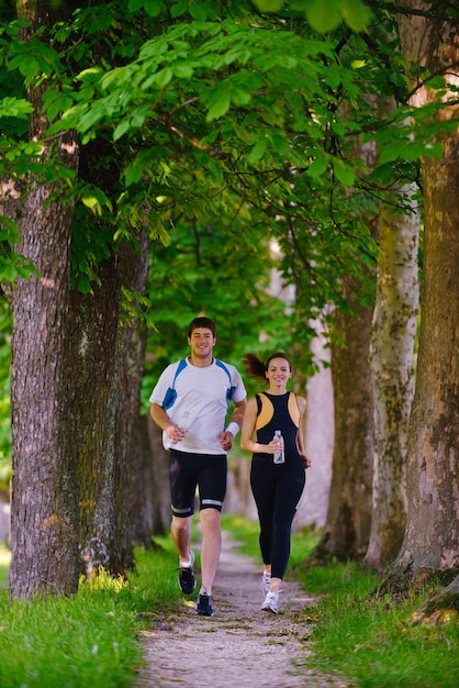 Giovani coppie che fanno jogging nel parco al mattino. Salute e fitness.